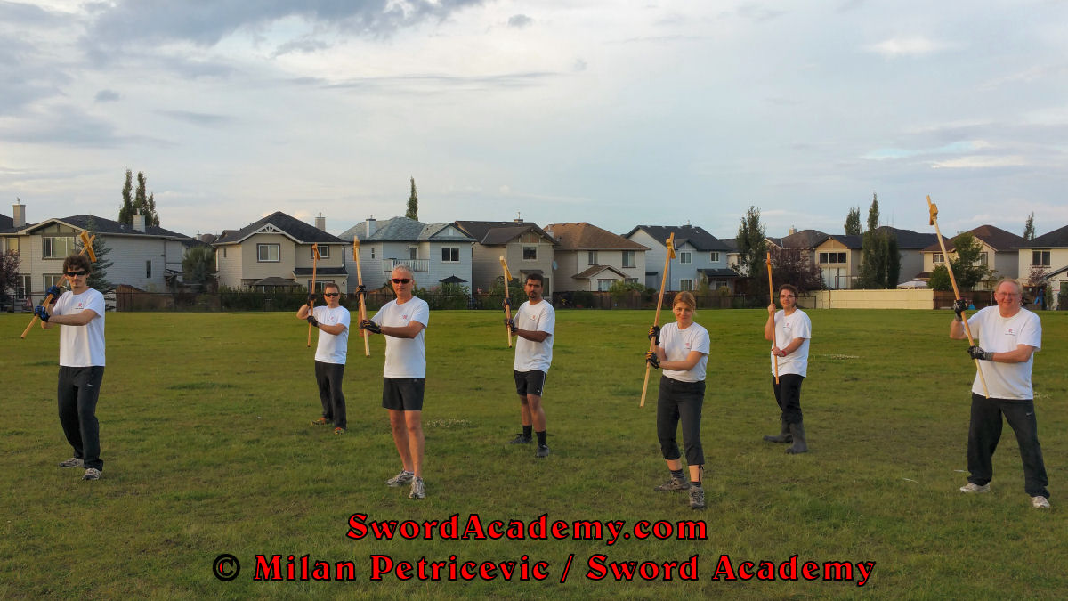 Sword Academy students in an outdoor class under Milan's supervision executes poleaxe solo / shadow training exercise / drill inspired by historical sources from the French and German medieval and renaissance tradition, part of Sword Academy HEMA / WMA / Martial Arts curriculum.