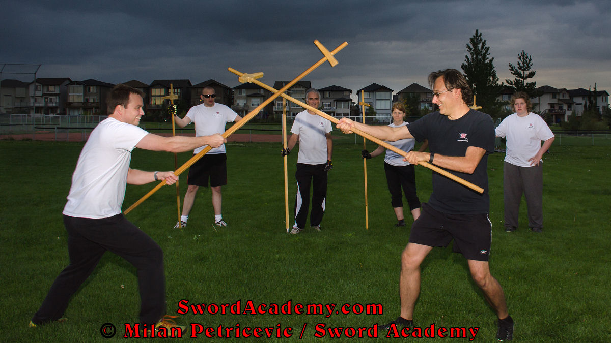 Milan demonstrates during an outdoor class in front of Sword Academy students and the stormy skies poleaxe / halberd exercise / drill as the weapons have crossed inspired by historical sources from the French (and German) medieval (and renaissance) tradition, part of Sword Academy HEMA / WMA / Martial Arts curriculum.