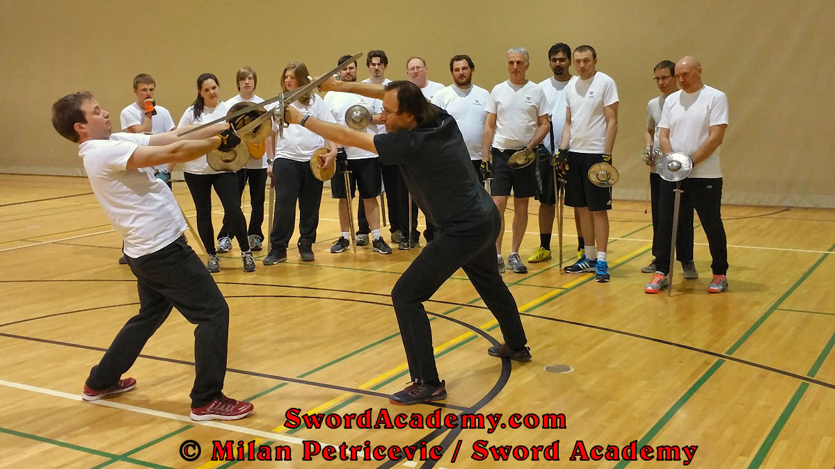 Demonstrating finer points of sword and buckler combat in a form of a drill inspired by historical sources in front of attentive students. Sources from German medieval tradition, form a part of Sword Academy HEMA / WMA / Martial Arts curriculum.